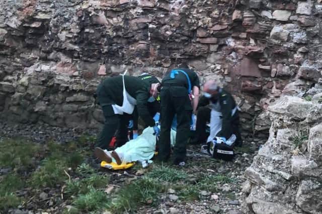 Tina Bates receiving help after falling from the ruins of Berwick Castle.