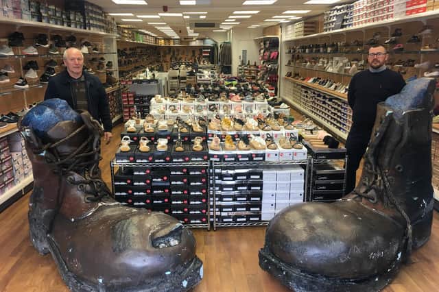 Arthur Punton, left, and Mark Punton with the giant boots inside the Marc Antony shop on Marygate in Berwick. Picture by Canon Alan Hughes.