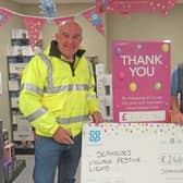 Seahouses festive lights chairman Ian Clayton accepting a grant from Seahouses Co-op staff member Gram Bateman.