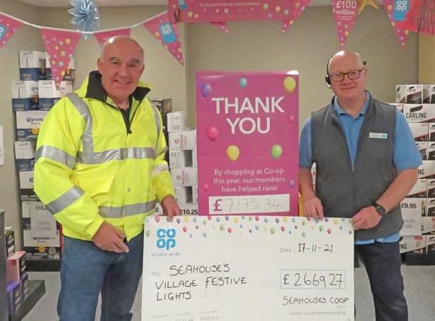 Seahouses festive lights chairman Ian Clayton accepting a grant from Seahouses Co-op staff member Gram Bateman.