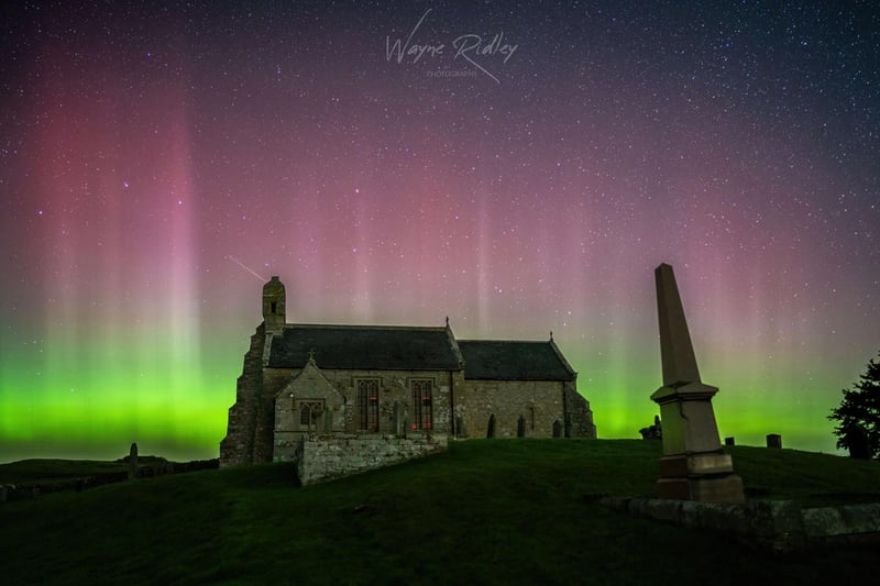 The northern lights seen over a church.