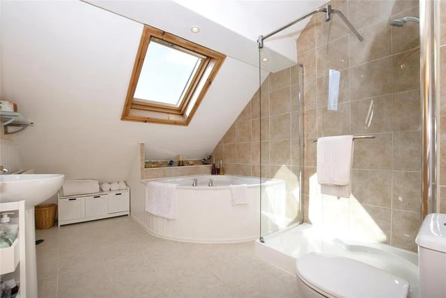 The main family bathroom is equipped with a jacuzzi-style bath and shower.