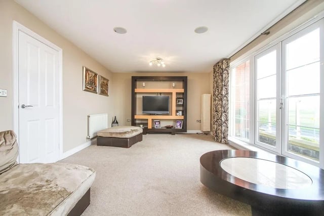 The living room is generously sized and flooded with natural light from the French doors to the balcony with stunning views of Seaton Sluice beach.