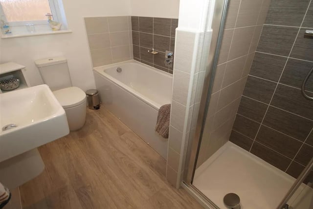 The well appointed family bathroom is furnished with a contemporary white suite, incorporating a panel bath and integral shower enclosure.