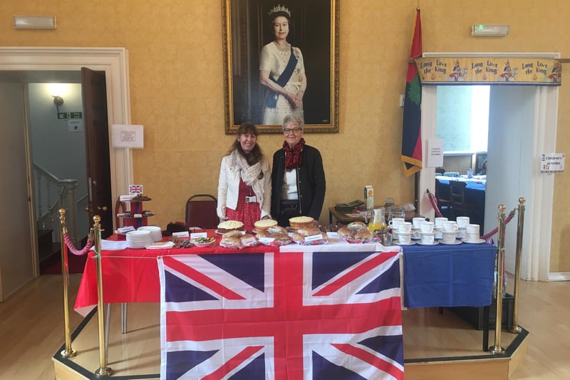 Linda Bankier and Margaret Shaw serve refreshments beneath the portrait of the late Queen in the Town Hall.