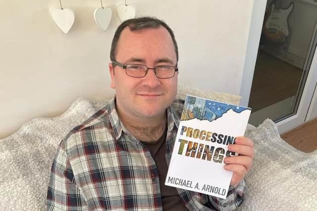 Author Michael A Arnold holding his new book 'Processing Things'.