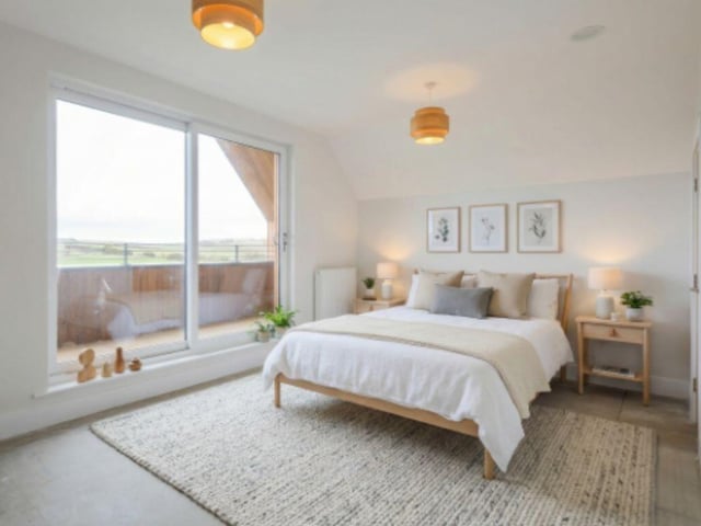 The master bedroom has an ensuite and access onto a deck that spans the full width of the house with views over the countryside.