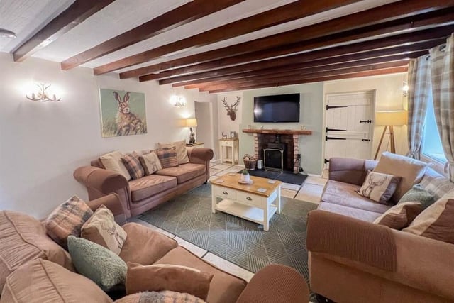 The generous lounge has a beamed ceiling and an inglenook fireplace with a log burning stove.