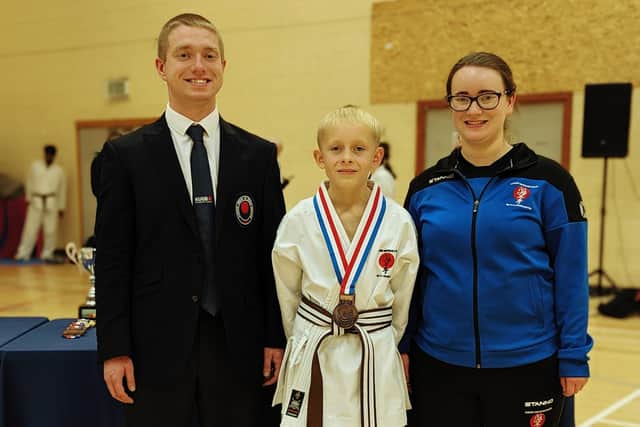 Jay Crosby shows off his bronze medal with club instructors Dylan and Gemma Gibson.