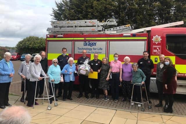 Staff and residents at Woodhorn Park care home with their local firefighters.
