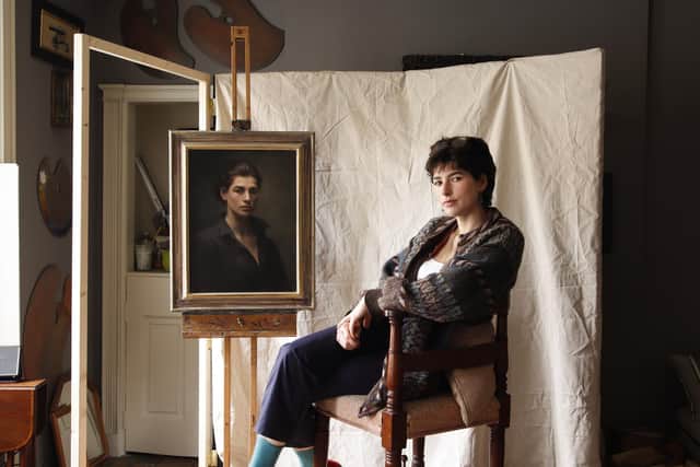 Phoebe Stewart Carter pictured sitting next to one of her paintings.