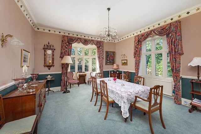 A superb formal dining room with period open fire and windows overlooking the garden.
