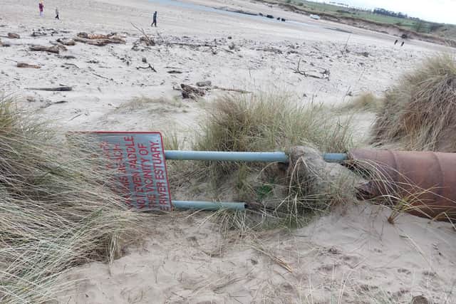 The estuary warning sign has been dug up and tipped over.