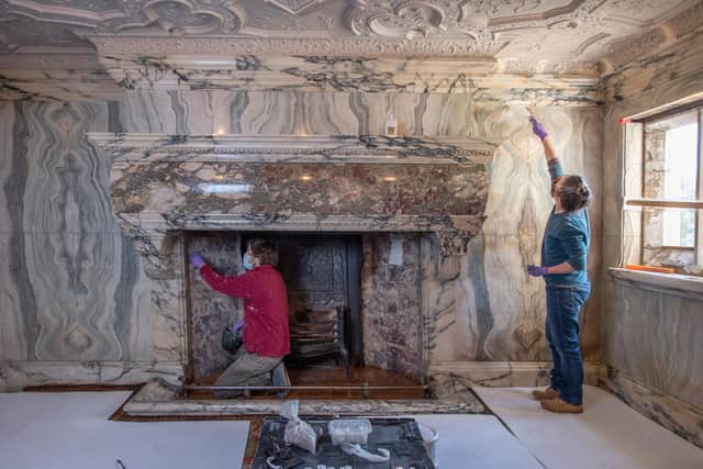 Conservators, Chloe Stewart and Alex Rickett, from Cliveden Conservation, carrying out repairs to the marble inside the inglenook fireplace.