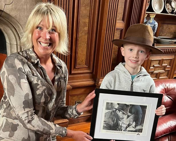 Bamburgh Castle's Claire Watson-Armstrong presents Indiana Jones fan Kit Matthews with a signed photo of Harrison Ford.