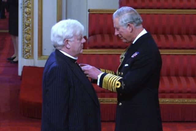Prince Charles at the time, now King Charles III, presenting Canon Alan Hughes with his MBE.