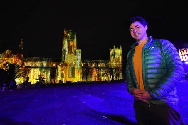 Durham Cathedral lit up with the "In Our Hearts Blind Hope" display by artist Zsolt Balogh, of Palma Studios pictured in front of his fantastic creation.