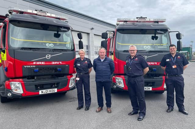 Coun Colin Horncastle, second from left, and Northumberland Fire and Rescue Service personnel next to the two new fire engines at Pegswood station.
