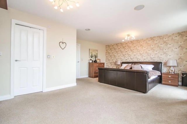 The master bedroom features a four-piece ensuite , fitted wardrobes, and an additional large balcony with seating space and views of the rear garden.