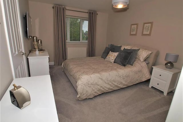 The principal bedroom includes fully fitted wardrobes and adjoining en-suite facilities.
