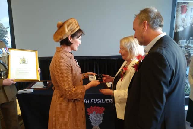 The Duchess of Northumberland presents the Elizabeth Cross to Calder Mills' family.