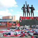 Fans have left tributes at the United Trinity statue at Old Trafford following the death of Sir Bobby Charlton. (Photo by John Peters/Manchester United via Getty Images)