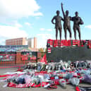 Fans have left tributes at the United Trinity statue at Old Trafford following the death of Sir Bobby Charlton. (Photo by John Peters/Manchester United via Getty Images)