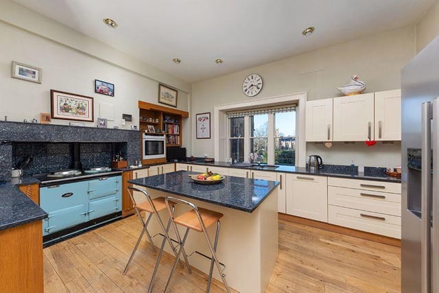 The kitchen/breakfast room with AGA and a range of cabinets and central island/breakfast bar.