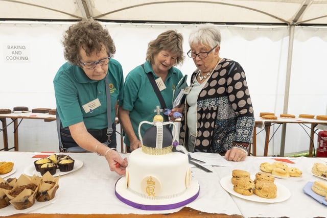 Stewards Margaret Gibson and Pauline Fairbairn with judge Margaret Onions considering an iced cake.