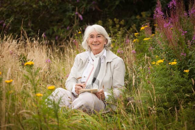 Picture of Dr Sarah Watkinson writing among flowers by Sarah Jamieson (Pictorial Photography).