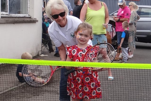A young festival-goer enjoys a spot of tennis.