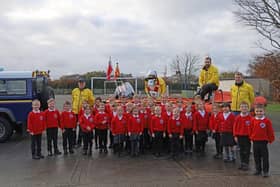 RNLI coxswain Keith Slater, mechanic Graeme Trotter and helmsman Tim Stienlet, with children of Seahouses Primary School.