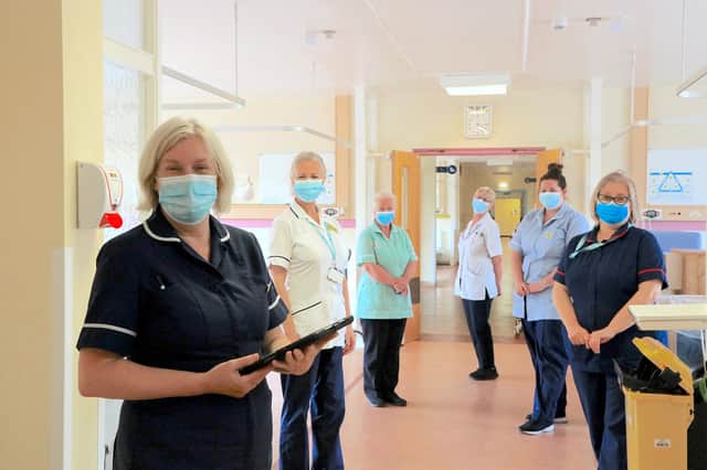 Sue Gibson, left in dark blue, Anna Wood, right in dark blue, and other staff on the ward before moving out.
