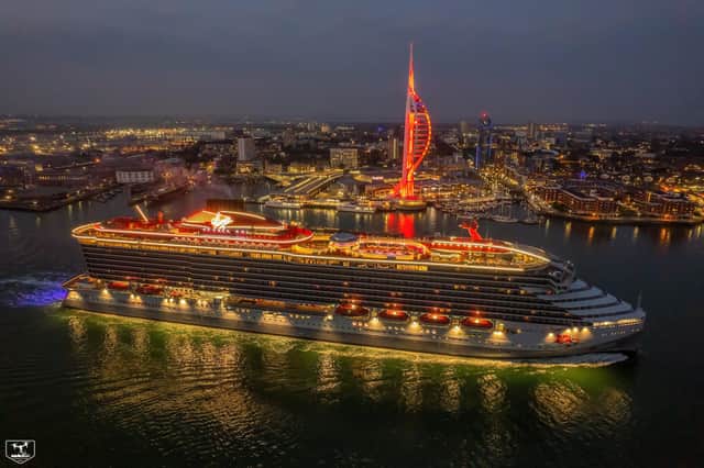 Virgin Voyages' Scarlet Lady passes the Spinnaker Tower which was lit up red last night for the occasion 
Picture: Dave Aird