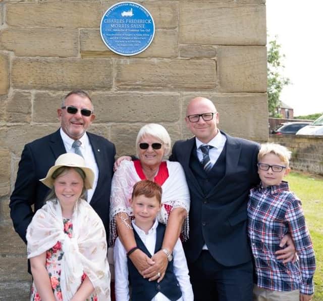 A proud Michael Saint (back left) and family with the blue plaque honouring Charles Saint.