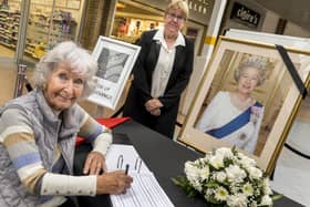 Margaret Watson MBE and Councillor Pat Heard with the Cramlington Town Council book of condolence in Manor Walks.