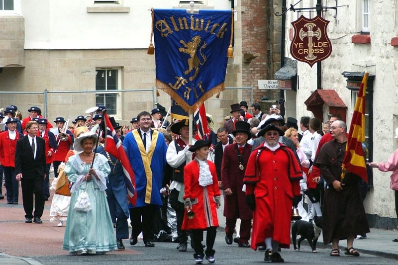 The Alnwick Fair procession passes Ye Olde Cross pub (now The Dirty Bottles) in 2003.