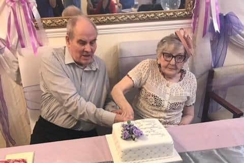 Hector and Marjorie Hewes cut a cake on their diamond wedding anniversary.