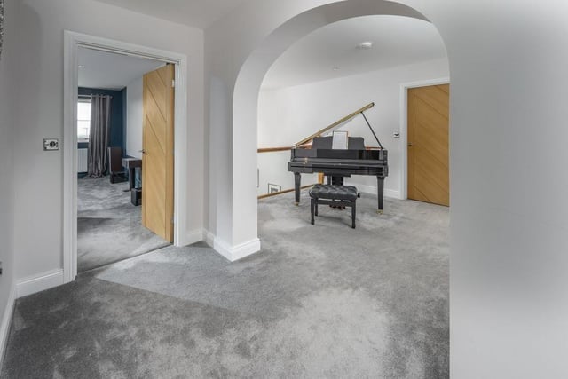 The spacious first floor landing currently includes an electric grand piano.