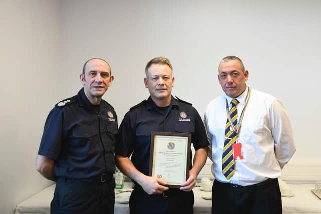 CFO Peter Heath (left) and Cllr Phil Tye, chair of the fire authority (right), present David with his award. (Photo by TWFRS)