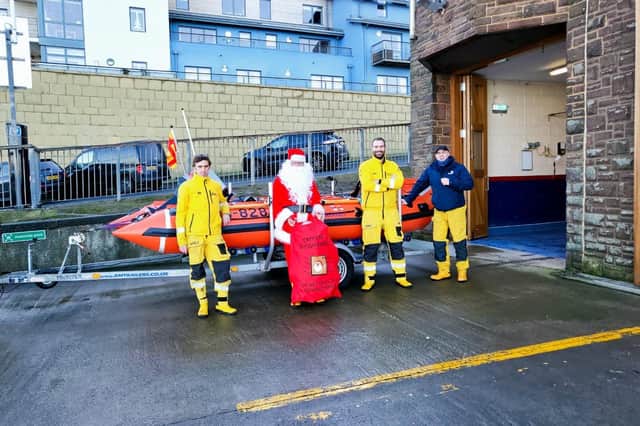 Crew members Tris Owens, Santa with his bag of gifts, Station Mechanic Graeme Trotter, and crew member Iain Saunders. Picture: Seahouses RNLI.