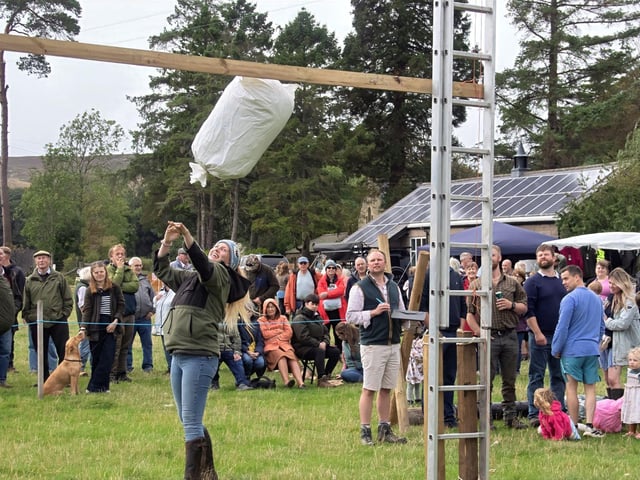 A competitor throwing a sack over the bar.