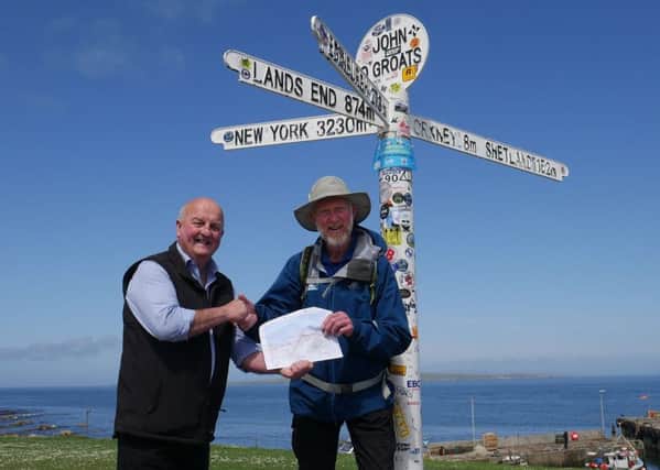 Councillor William MacKay greets Brian Burnie at the iconic John OGroats sign in Scotland.