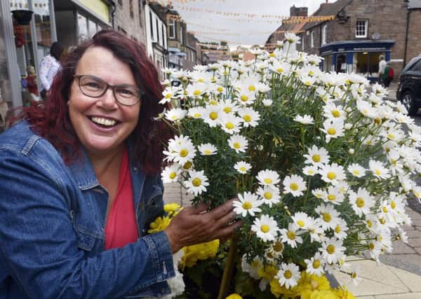 Catherine Dunn with one of the planters in the centre of Wooler. Picture by Jane Coltman