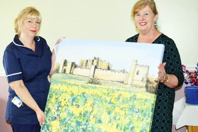 Brenda Longstaff (right), head of arts and patient environment programme at Northumbria Healthcare, presents Michelle Mole, acting ward manager at Alnwick Infirmary, with a picture for the refurbished day room