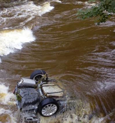 A car in the river at Thrum Mill.