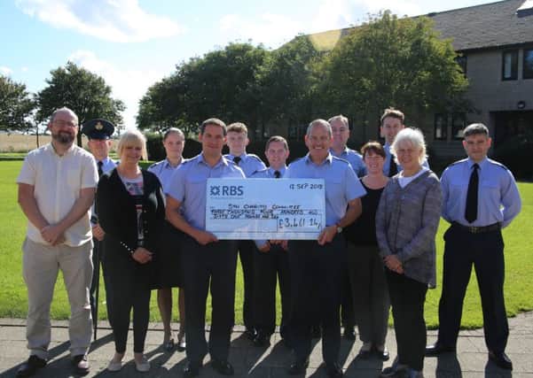 Flight Lieutenant Mike Petley (left of cheque), Group Captain Cowieson (right of cheque), alongside members of the RAF Boulmer Charities Committee and representatives from Real Deal Plus and Tyneside and Northumberland Mind. Picture by Simon Moore