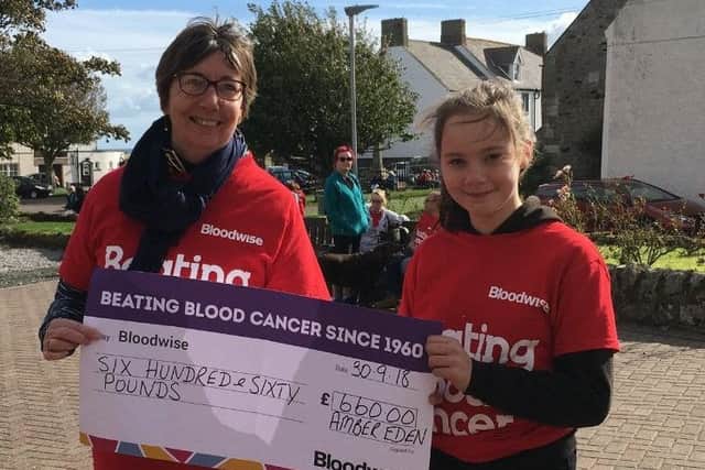 Amber Eden presents a cheque for Â£660 to Helen Tait of Bloodwise, which she raised by competing in the Junior Great North Run. Amber was running in memory of her uncle, Stuart Renton.