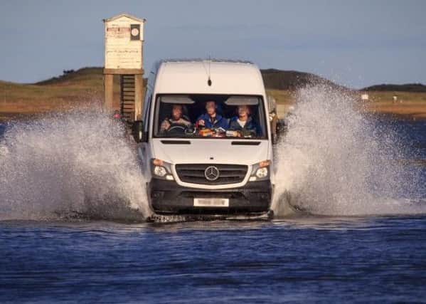 The van driving along a flooded Holy Island causeway after the safe-crossing times.