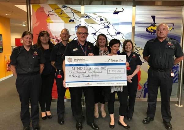 Northumberland Fire and Rescue Chief Fire Officer, Paul Hedley, presents a cheque to Mind.